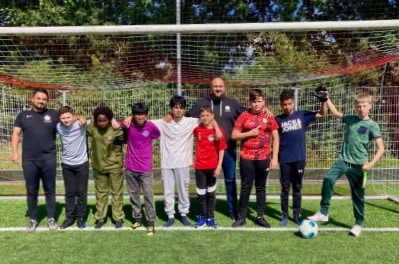Selçuk Akpinar met een aantal jonge voetballers in het doel.
