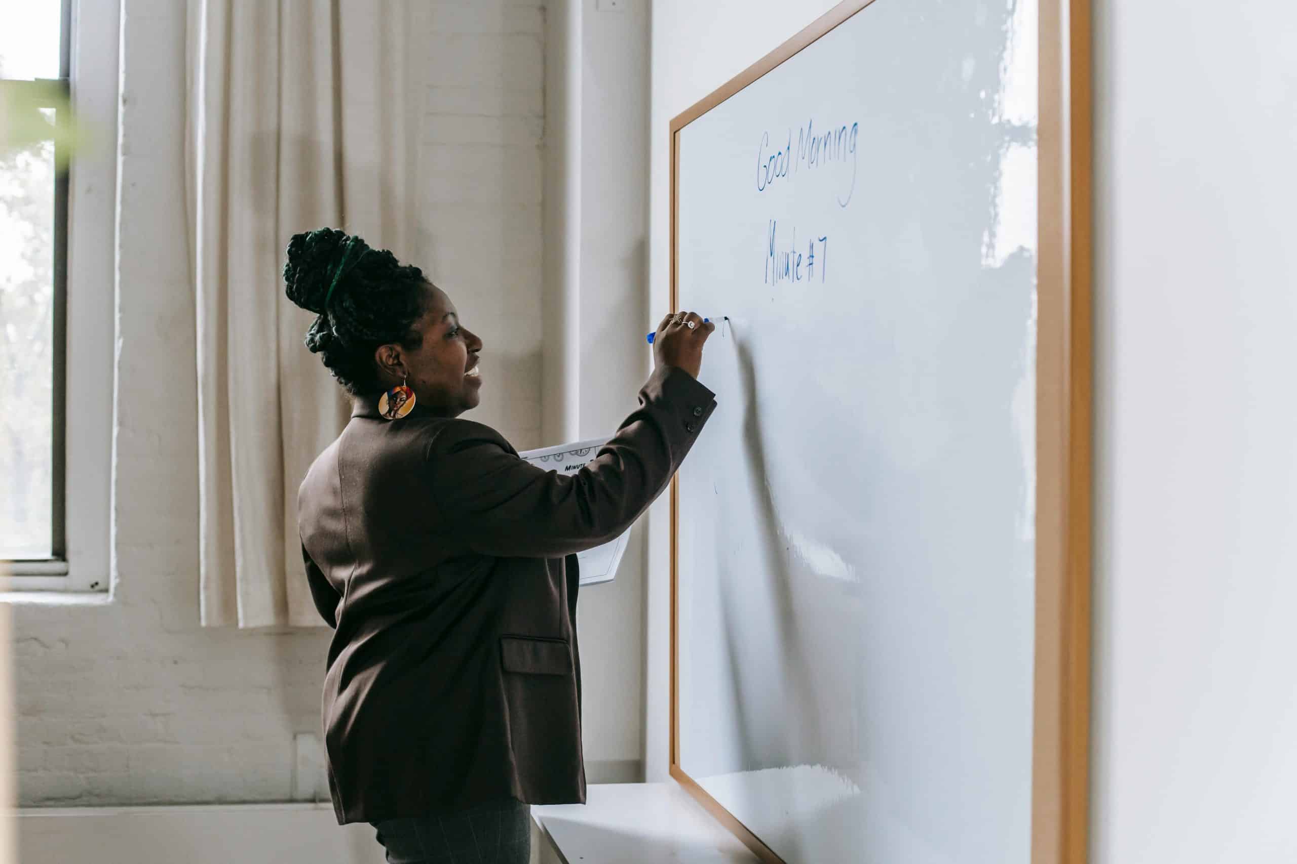 Dame schrijft iets op whiteboard