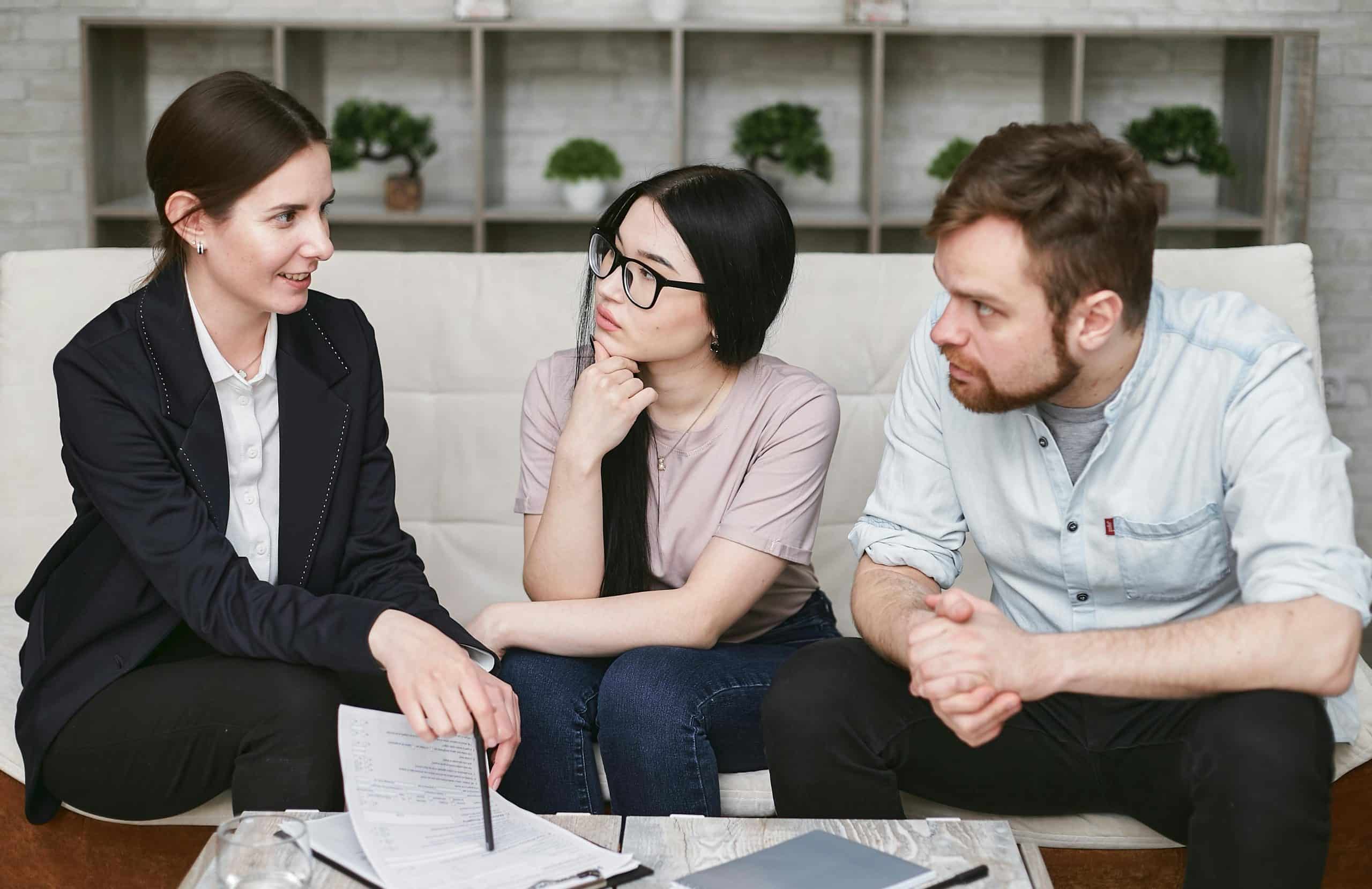 Een man en een vrouw krijgen uitleg van een andere vrouw