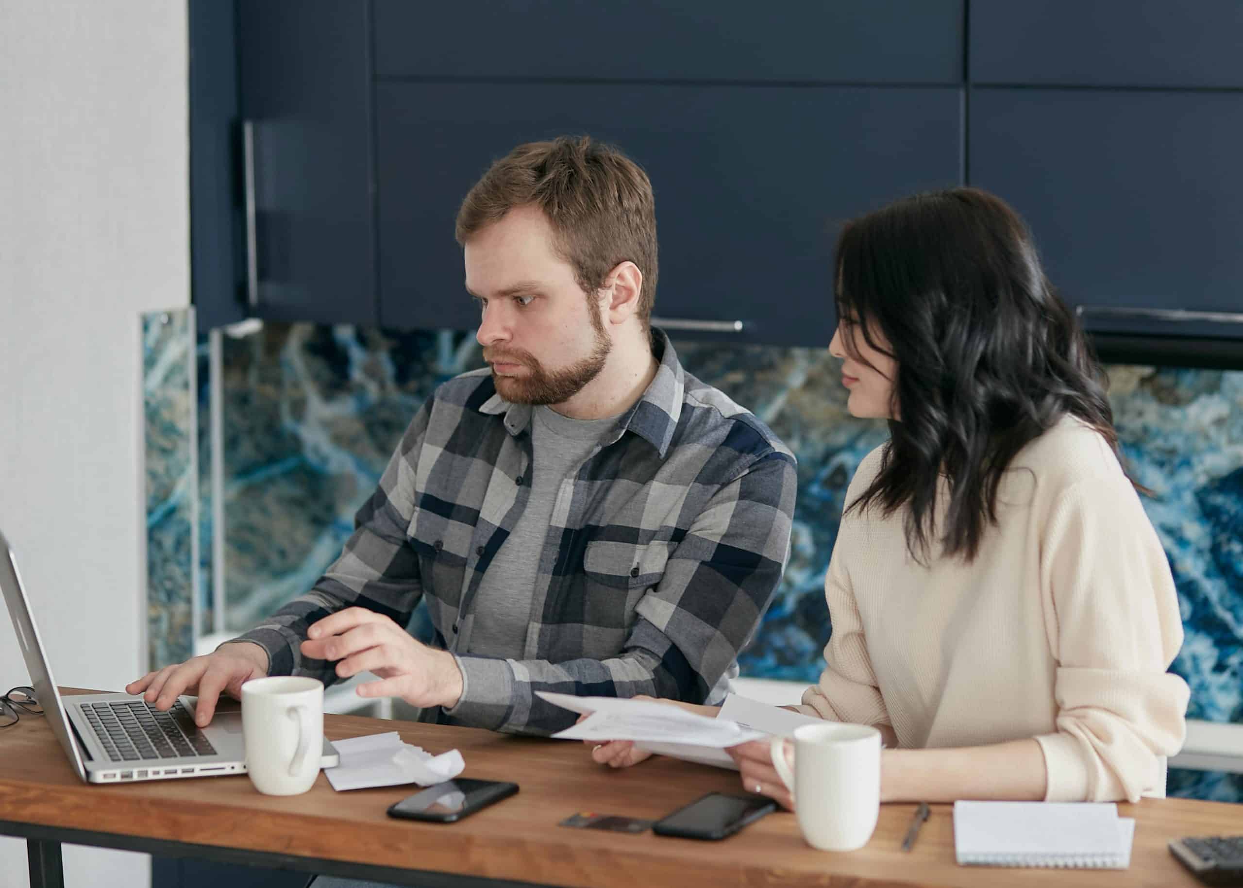 Twee mensen zijn administratie aan het doen achter een computer