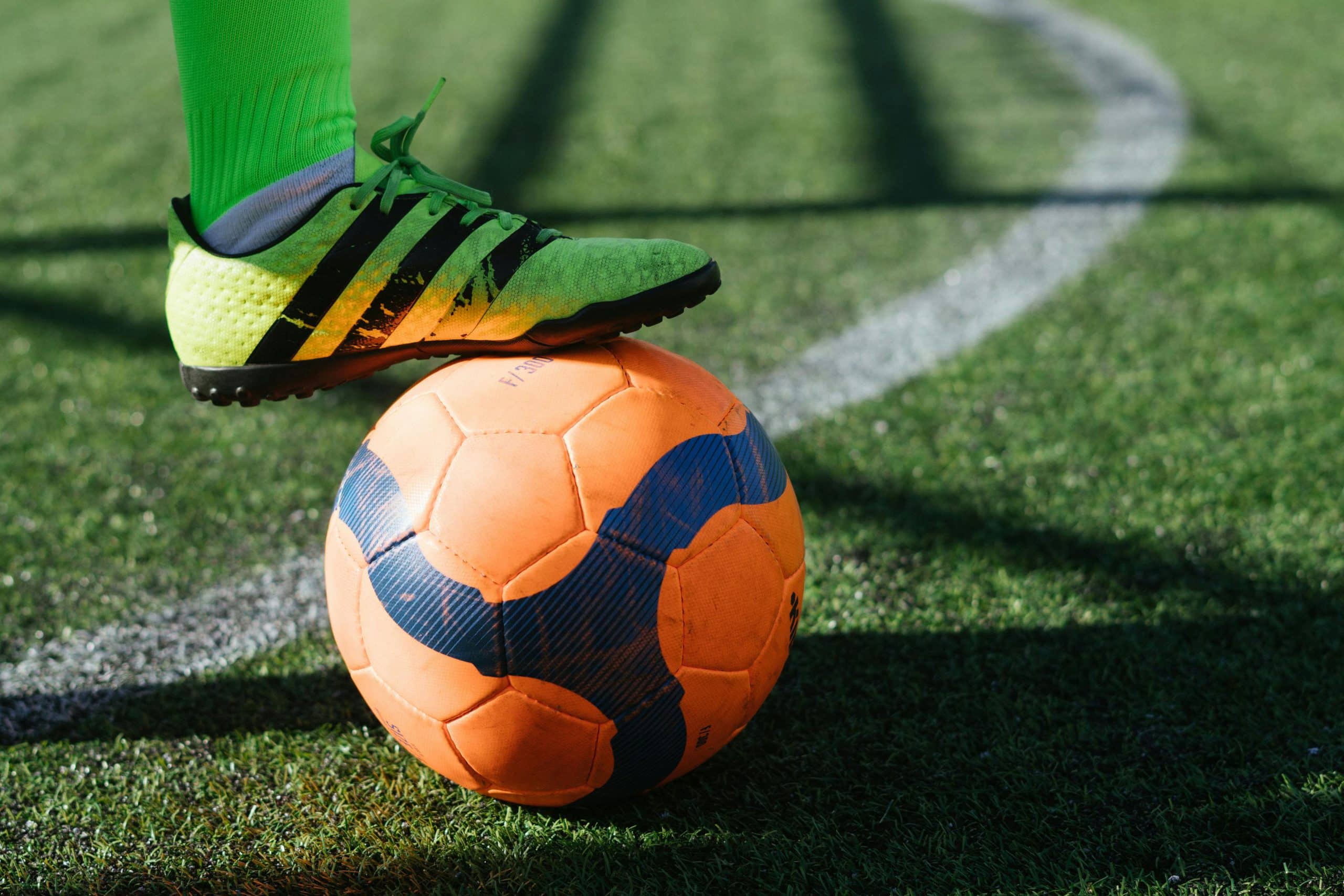 Een voet die op een voetbal rust